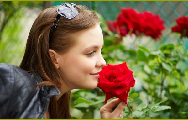 Женщина нюхает цветок